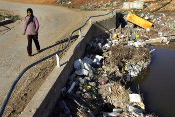 UMBETIN, ISRAEL - JANUARY 10: A Bedouin Arab girl walks barefoot across a bridge over the heavily polluted Nahal Hebron stream, laden with raw sewage, toxic industrial waste and dumped rubbish, as it passes January 10, 2007 through the unrecognized Bedouin Arab village of Umbatin in Israel's Negev desert. Living on the edge of modern Israeli society in unrecognized villages amongst the industrial parks and near the Jewish communities on land they lay claim to, many of the Negev Bedouins suffer from malignant, genetic and respiratory diseases. They also have the highest infant mortality rate in Israel. (Photo by David Silverman/Getty Images) Industrialization Threatens Traditional Bedouin Lifestyle. Photographer. Encyclopædia Britannica ImageQuest. Web. 24 Jan 2014. 